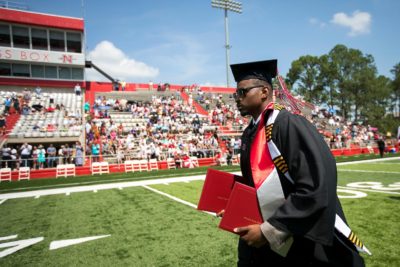PICTURE of student walking with diplomas