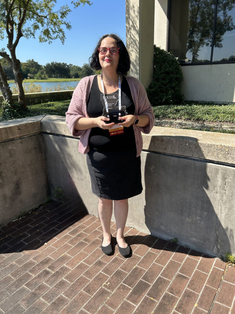 Government Information Librarian Jessica Hawkes poses with Unsung Hero Award.