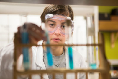 chemistry student with test tubes