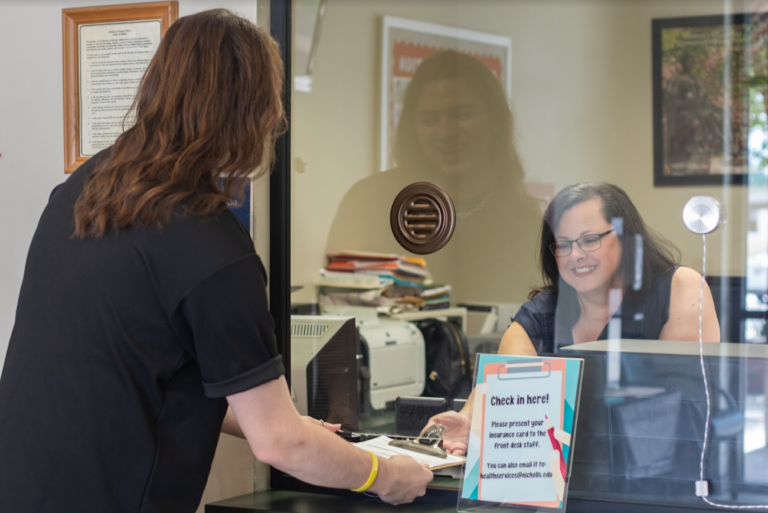 A student checks in at the University Health Services front desk.